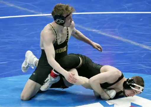  ?? Associated Press ?? Iowa’s Spencer Lee, right, a Franklin Regional graduate, won decisively against Purdue’s Devin Schroder in the quarterfin­als Friday in St. Louis. He won later in the day to advance to Saturday’s final at 125 pounds.