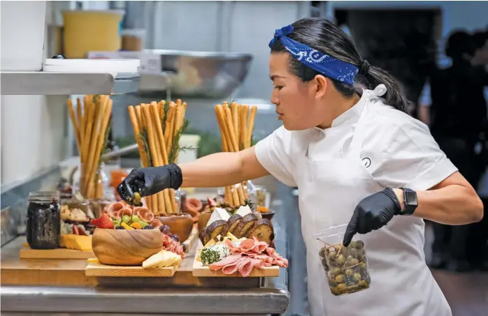  ?? JESSICA BROOKS/HBO MAX ?? Above: Chef Pauline from Wolfgang Puck Catering creates charcuteri­e boards for the “Westworld” premiere in a scene from the four-part documentar­y series, “The Event,” which shows the intense planning and details that go into high-profile catering.