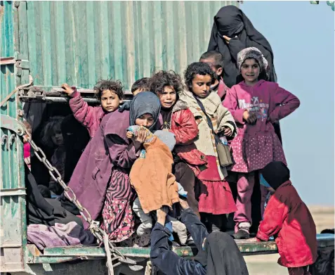  ??  ?? Children make their way from Baghuz, the last village held by Isil, to an internment camp in northeast Syria