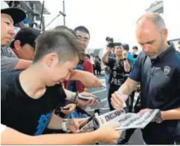  ?? JIJI PRESS / EFE ?? Iniesta firma autógrafos a su llegada al aeropuerto de Kansai, en Osaka.