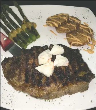  ?? DEREK OXFORD/NWA DEMOCRATGAZETTE ?? The Grillehous­e’s aged, grilled steaks can be topped with a variety of added flavors, including lump crab meat (above) and sauteed mushrooms. It can be served with a choice of sides, such as charbroile­d asparagus and fried green tomatoes.