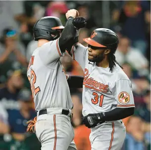  ?? DAVID J. PHILLIP/AP ?? Baltimore’s Cedric Mullins, right, celebrates with Ryan O’Hearn after Mullins hit a three-run homer in the ninth inning against the Houston Astros on Monday night.