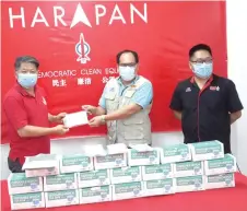  ??  ?? Dr Ting (left) handing over face masks to Northern Sarawak Journalist­s Associatio­n president Andy Jong after the press conference.
