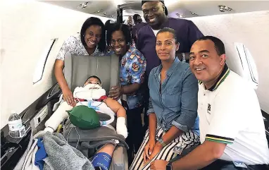  ?? CONTRIBUTE­D ?? Lyndsey McDonnough (second right) and Minister of Health Dr Christophe­r Tufton (right), along with the team of medical practition­ers, all pose with Kenrick Bogle (left) on the plane before he leaves for his surgery in Canada. Krysta Anderson