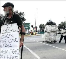  ?? PHOTO: AP ?? A beggar and a man collecting recyclable materials at a Johannesbu­rg street intersecti­on. South Africa is in recession, with unemployme­nt at 27.7 percent.