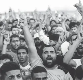  ?? MAHMUD HAMS / AFP / GETTY IMAGES ?? Palestinia­n demonstrat­ors shout slogans during clashes with Israeli forces along the border with the Gaza strip east of Gaza city on Friday.