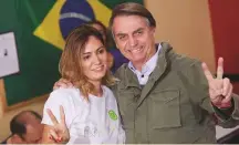  ?? AP ?? Jair Bolsonaro flashes a victory sign alongside his wife Michelle during the runoff in Rio de Janeiro.