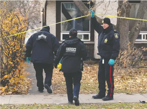  ?? KEVIN KING/POSTMEDIA NEWS ?? Forensics officers enter a homicide scene in Winnipeg on Sunday. A 14-year-old girl was killed and an 18-year-old is in hospital in stable condition after a stabbing attack, one of a string of violent attacks in recent weeks in the Manitoba capital.