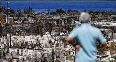  ?? JAE C. HONG/ASSOCIATED PRESS ?? A man surveys the ruins of Lahaina, Hawaii, site of the deadliest U.S. wildfire in more than a century. At least 115 people have been confirmed dead, but Maui County authoritie­s expect that number to increase.