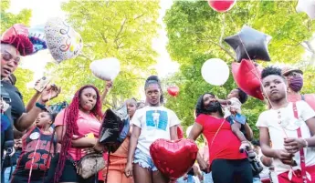  ?? TYLER PASCIAK LARIVIERE/SUN-TIMES ?? Family members, friends and residents gather Friday for a balloon release and memorial for 11-year-old Ja’lon James at 18th Street and South Avers Avenue.