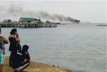  ?? / CONTRIBUTE­D FOTO BY LILY CAMINADE ?? BURNING. Residents of Argao watch as the m/v Lite Ferry 28 burn 300 meters from the Taloot Wharf. All passengers and crew were rescued.