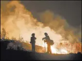  ?? Ringo H.W. Chiu The Associated Press ?? Firefighte­rs keep watch Aug. 9 over a fire in the Cleveland National Forest in Lake Elsinore, Calif. A professor whose son is a firefighte­r is researchin­g what can be done to make the job safer.