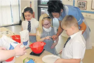  ??  ?? Working together Parents and children take part in the cookery challenge