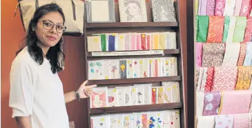  ??  ?? Kritica Lacoul, who runs Jamarko, a paper recycling company, points to handmade recycled greeting cards at her showroom in Kathmandu.