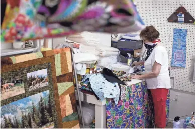  ?? MARK HENLE/THE REPUBLIC ?? Julie Reiman presses face masks on June 30 in her shop, Julie's Quilt Shop, in Miami. The shop can't keep up with the demand for masks.