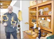  ?? (NWA Democrat-Gazette/Rachel Dickerson) ?? Frank DiNino of Bentonvill­e holds two of his newest wood art pieces beside a collection of his work at the Wishing Spring Gallery in Bella Vista.