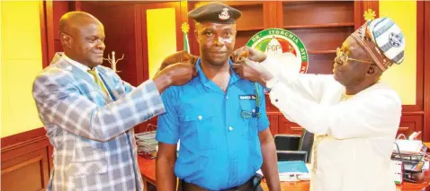  ?? ?? Peoples Democratic Party ( PDP) National Chairman, Dr. Iyorchia Ayu ( right); supported by his Chief Security Officer ( CSO), ASP Aniedi Edet ( left) while decorating one of his security aides, Sgt. Timothy Hembe with his new rank of Inspector, at Wadata House, Abuja… yesterday.