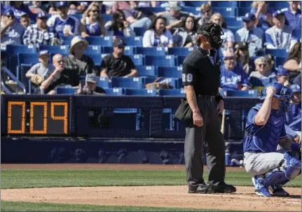  ?? MORRY GASH – THE ASSOCIATED PRESS ?? Home plate umpire Jim Wolf waits as the pitch clock counts down during the first inning of Saturday's game between the Dodgers and Brewers.