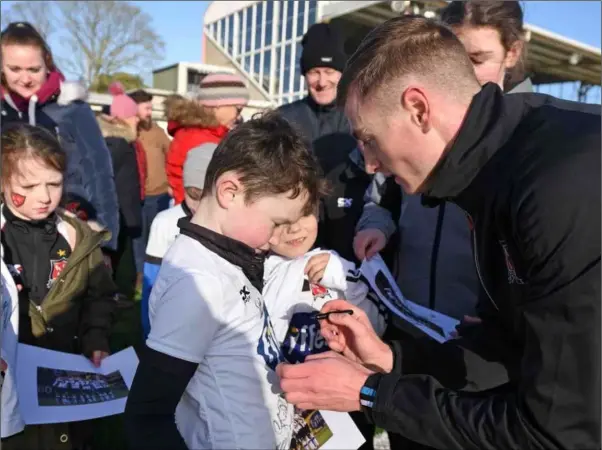  ??  ?? New Dundalk signing Daniel Kelly signs a young supporter’s jersey at the open training session at Oriel Park on Sunday.