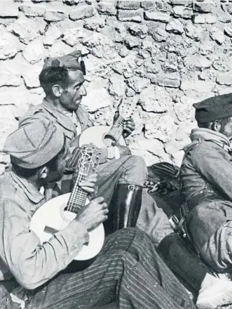  ?? GETTY NEUS MASCARÓS ?? Soldados de las tropas franquista­s se relajan con un poco de música. Imagen que aúna ambos textos, tomada durante el mes de noviembre de 1936