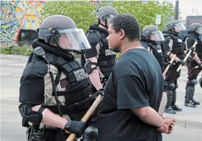  ?? JIM MONE THE ASSOCIATED PRESS ?? A protester goes face-to-face with a Minnesota state trooper on Friday after another night of protests over the death of George Floyd, a Black man who died in police custody on Monday in Minneapoli­s.