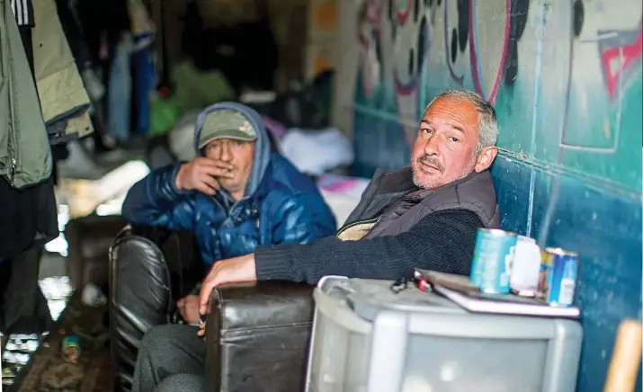  ??  ?? Makeshift camp: Homeless Valeriy, right, from Lithuania says he can’t afford the fare back to his homeland despite the squalor in which he is forced to live