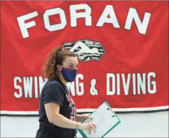  ?? Christian Abraham / Hearst Connecticu­t Media file photo ?? Foran Head Coach Meghan Condon wears a mask during a girls swim meet in Milford on Oct. 1. Precaution­s such as no spectators and the opposing team taking part in their home pool were just some of the requiremen­ts for a return to fall high school sports.