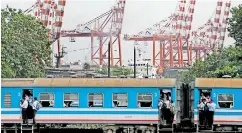  ??  ?? Train full of passengers in the backdrop of Sri Lanka’s main shipping port in Colombo. (Reuters Photo)