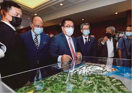  ?? PIC BY MOHAMAD SHAHRIL BADRI SAALI ?? Melaka Chief Minister Datuk Sulaiman Md Ali (centre) and other officials looking at a model of the Melaka Waterfront Economic Zone in Kuala Lumpur yesterday.