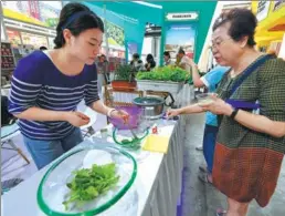  ?? ZHANG NAN / XINHUA ?? A visitor tastes fresh vegetable salad offered by an exhibitor at the 16th China Changchun Internatio­nal Agricultur­e and Food Fair, which closed on Sunday in Changchun, Jilin province.