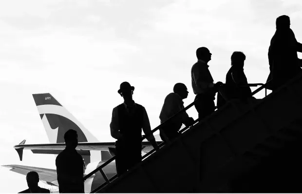  ?? CHRIS YOUNG / THE CANADIAN PRESS ?? Guests board a plane in an Air Canada hangar in Toronto Tuesday as the airline launches its new “leisure carrier” Air Canada Rouge.