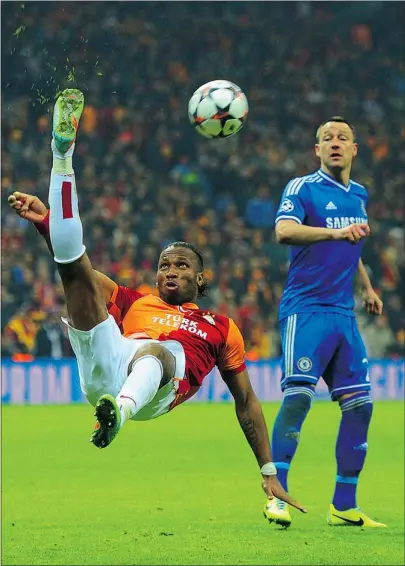  ?? — GETTY IMAGES ?? John Terry of Chelsea looks on as Didier Drogba of Galatasara­y clears the ball during their Champions League round of 16 first leg match on Wednesday in Istanbul, Turkey.