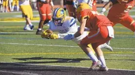  ?? KIM HAIRSTON/BALTIMORE SUN ?? Jordan Moore stretches to get the ball across the goal line ahead of Calvert Hall’s Tre’ Jordan for Loyola's only touchdown in 99th Turkey Bowl.