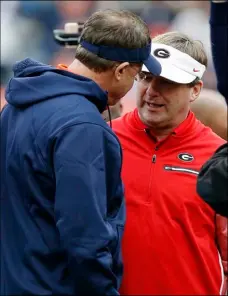  ??  ?? In this Nov. 11 file photo, Auburn head coach Gus Malzahn (left) and Georgia head coach Kirby Smart meet before an NCAA college football game in Auburn, Ala. No. 6 Georgia is getting ready for a rematch with No. 4 Auburn in the SEC championsh­ip game....