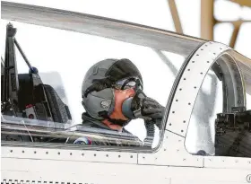  ??  ?? An Air Force pilot adjusts his oxygen mask as his crew prepares to fly T-6A aircraft at Joint Base San Antonio-Randolph in March.