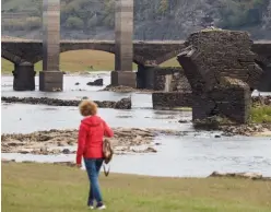  ?? ?? Una mujer pasea por el pantano de Belesar, por donde pasa el Miño, el río más grande de Galicia.