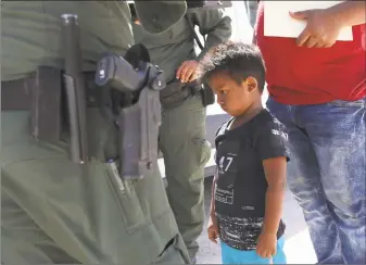  ?? John Moore / Getty Images ?? A boy and father from Honduras are taken into custody by U.S. Border Patrol agents near the U.S.-Mexico Border on June 12 near Mission, Texas. The asylum seekers were then sent to a U.S. Customs and Border Protection processing center for possible separation. A handful of these children have ended up in Connecticu­t, their families detained elsewhere.