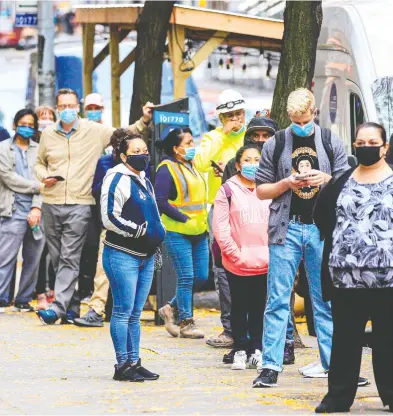  ?? KENA BETANCUR / AFP VIA GETTY IMAGES ?? People line up outside a COVID-19 testing site in New York City on Wednesday. The city's public school system will
have to shut down if the infection rate in the city rises much further, says Mayor Bill de Blasio.