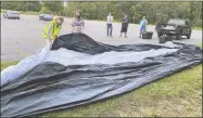  ?? Contribute­d photo ?? Torrington Library Teen Advisory Board members Maia Blauvelt, in safety vest, and Ellie Ercoli unfold the inflatable 40-foot screen.