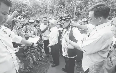  ??  ?? GAP: Abdul Karim (kanan) ngerasuk baju Bidayuh ba tubuh Abang Johari ba pengerami bejadi Borneo Tribal Village kemari.