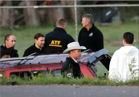  ?? Picture: Eric Gay ?? „ Officials investigat­e the scene where a suspect in a series of bombing attacks in Austin blew himself up as authoritie­s closed in.