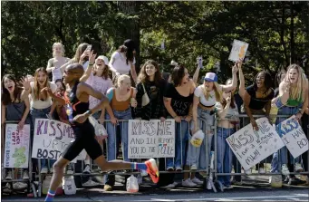  ?? LIBBY O’NEILL — BOSTON HERALD ?? Wellesley College students cheer as racers pass by in Wellesley.