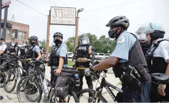  ?? PAT NABONG/SUN-TIMES ?? Chicago Police Department officers and Illinois State Police form a human barricade Saturday in the Bronzevill­e neighborho­od to keep anti-police brutality protesters off the Day Ryan Expressway.