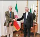  ?? ?? In this photo released by the Iranian Foreign Ministry, Enrique Mora, a leading European Union diplomat, left, shakes hands with Iran’s top nuclear negotiator Ali Bagheri Kani in Tehran, Iran, March 27, 2022. Mora, the European Union coordinato­r of talks to revive Iran’s nuclear accord with world powers said Tuesday, May 10, 2022, that he was traveling to Tehran, as the bloc makes a last-ditch effort to salvage the deal after a weeks-long standstill. (AP)