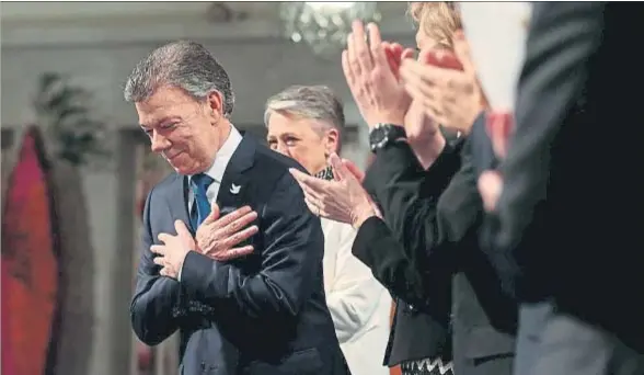  ?? NTB SCANPIX / REUTERS ?? Juan Manuel Santos agradece los aplausos, ayer durante la entrega del Nobel de la Paz, en el Ayuntamien­to de Oslo