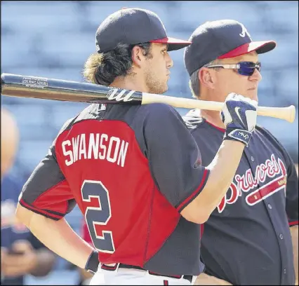  ?? CURTIS COMPTON /CCOMPTON@AJC.COM ?? Dansby Swanson talks with hitting coach Kevin Seitzer during batting practice while making his MLB debut last week at Turner Field. Swanson went 2 for 4 in his first game.