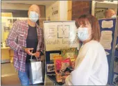  ?? ?? Youth worker Phil Edwards and Kintyre Care Home wellbeing coordinato­r Susan Ellis swap goodies during the gift exchange.