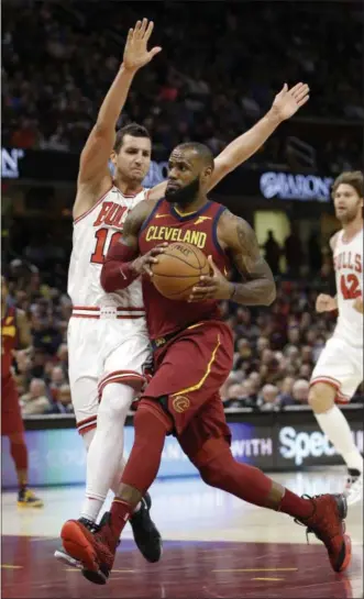  ?? TONY DEJAK — THE ASSOCIATED PRESS ?? LeBron James drives past the Bulls’ Paul Zipser in the first half at Quicken Loans Arena on Oct. 24.