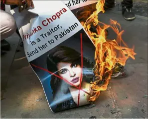  ??  ?? Sensitive topic: Members of the fringe Hindu outfit Hindu Sena burning a poster bearing an image of Chopra. — AFP
