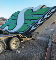  ??  ?? A Saskatchew­an Roughrider­s sign sits on a trailer while workers using heavy machinery continue to dismantle Taylor Field.